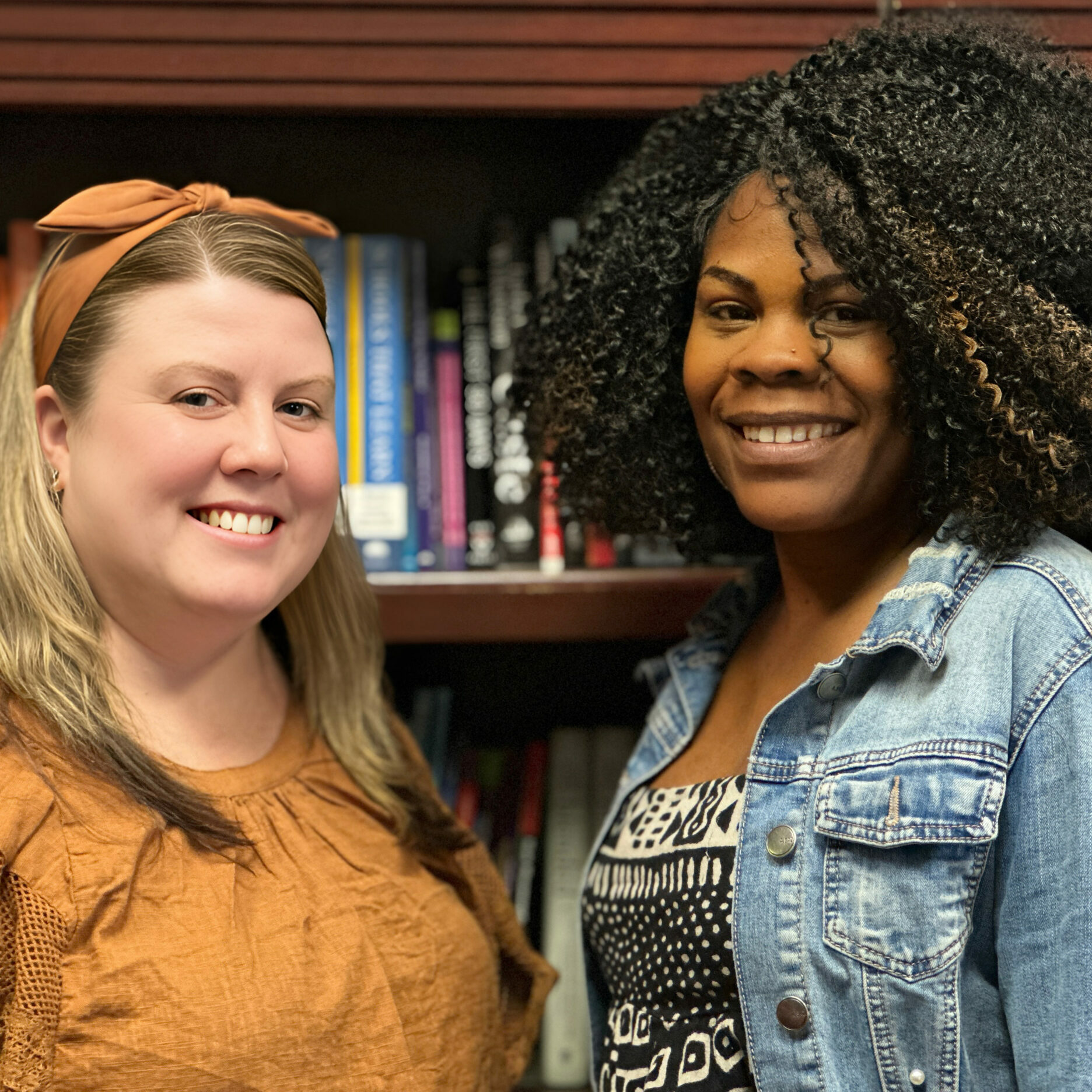 George W. Nebinger School Leadership Team Ayana Townsend, Principal of George W. Nebinger School, and Caroline Pomrink, Assistant Principal, smiling together in front of a bookshelf at the school in Philadelphia.